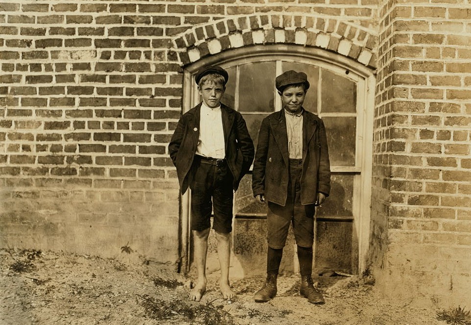 (Right Hand boy) John Campbell, (Box 294 Gastonia N.C.) 10 years old. Been three years in mill. In school part of this time. (Left hand boy) Roy Little. Said 12 years old. 2 years in mill and worked nights 9 months. Doffer. Location: Gastonia, North Carolina. Nov. 1908