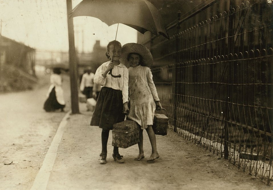 A couple of dinner-toters at Riverside Cotton Mills, Danville, Va. Myriads of these little ones carry dinners to the mill workers. The Supt. of Schools and teachers in Danville said that many children toted dinners and did nothing else not even attending school. Location: Danville, Virginia. ca. 1910 photo by Lewis Hines