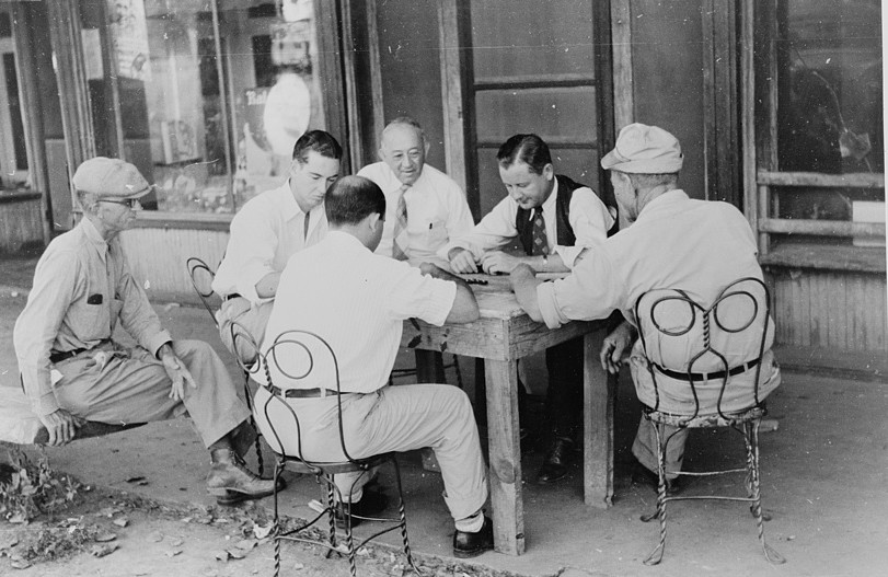 Playing dominoes or cards in front of drug store in center of town in Mississippi Delta, Mississippi Oct. 1939 photographer Marion Post Wolcott