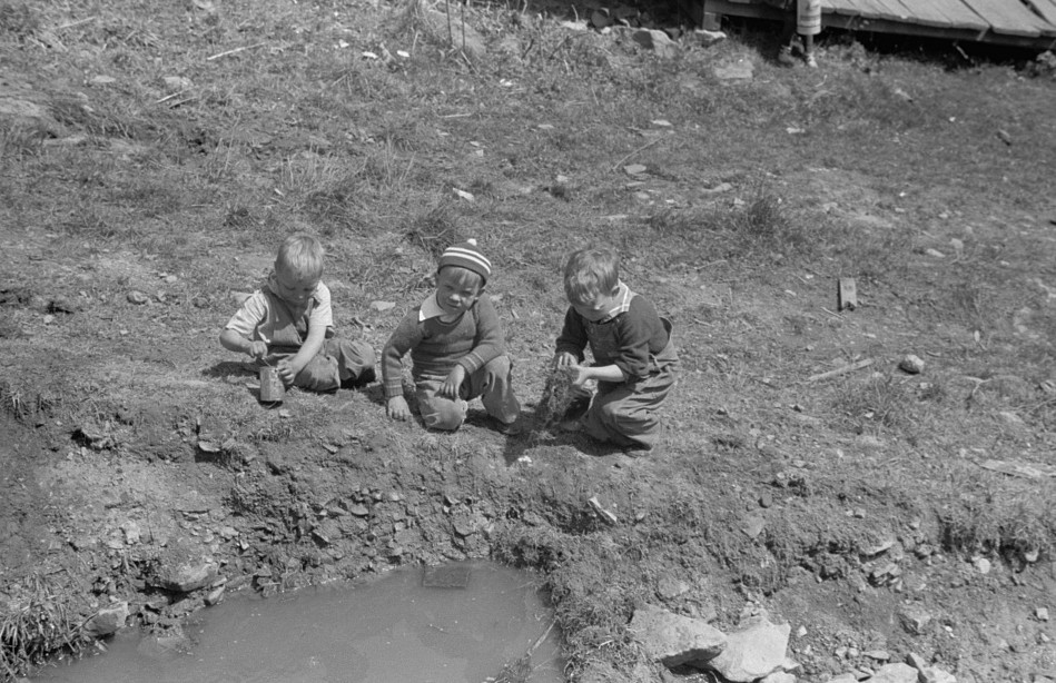 Children playing in street gutter in front of their home. Company coal town, Kempton, West Virginia