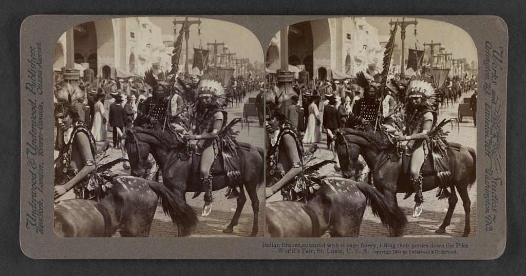 Indian braves, splendid with savage finery, riding their ponies down the Pike, World's Fair, St. Louis